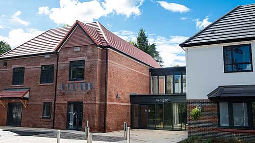 A modern brick building with a reception area, featuring a mix of traditional and contemporary architectural styles.