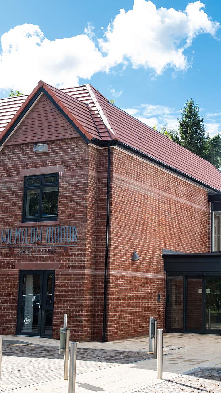 A modern brick building with a reception area, featuring a mix of traditional and contemporary architectural styles.