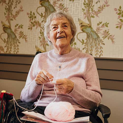 An elderly woman enjoying knitting