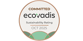 This is the ecovadis logo. The logo in a circle shaped badge and announces we are committed to ecovardis as of october 2025. The colours on the badge are gold, beige and green.