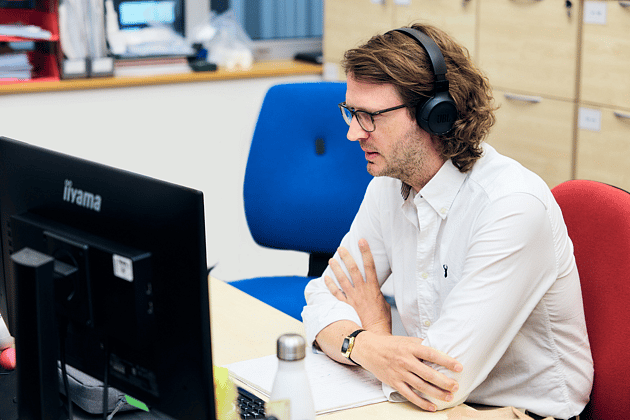 Adelphi 1142 EDITED Person with headphones given support via the screen