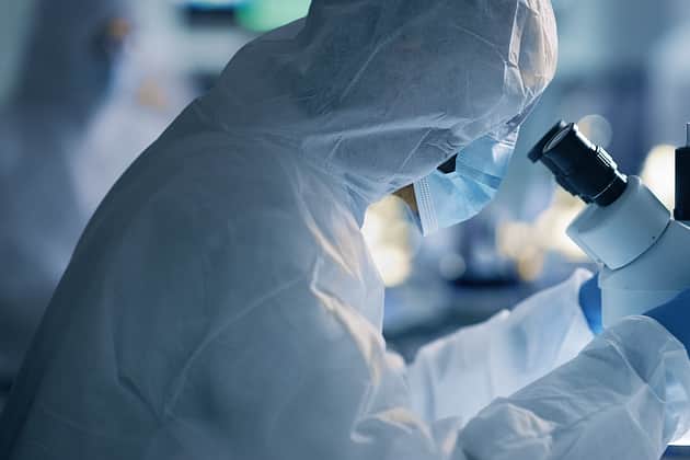 Suited Lab Staring into microscope