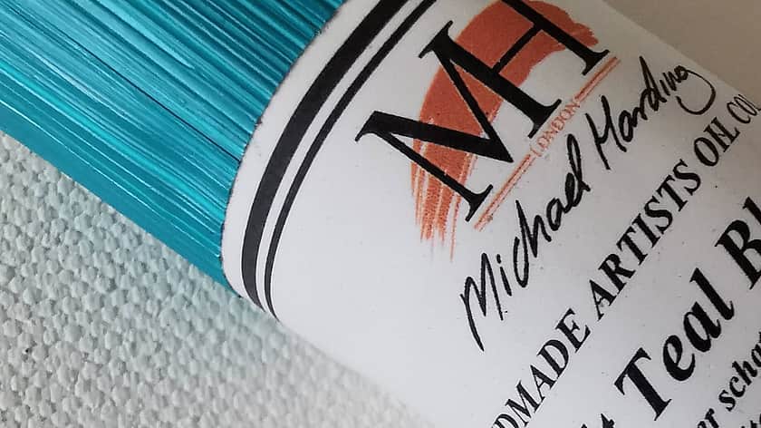 a close up of a turquoise paint container with a branded Michael Harding label on the front