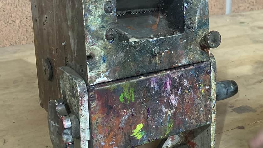 a shot of a old and very used machine which is paint splattered