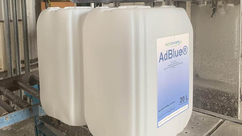 two large white jerry cans standing next to each other, the front one has a large label on the front which is white at the top, fading to blue with the AdBlue logo on the top