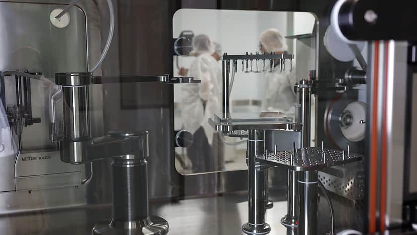 Ein Blick auf wissenschaftliches Personal durch das Fenster eines Isolators.