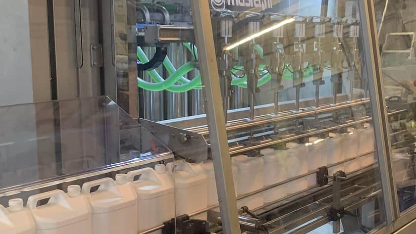 a Masterfil machine with a line up of white jerry cans filing into it, ready for filling