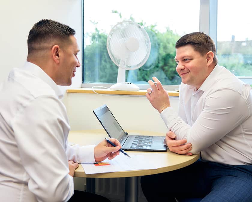 Two men in a meeting, discussing work.
