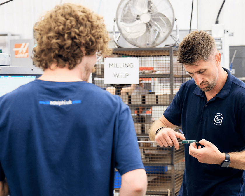 Two Men Working Together On Fixing A Tool