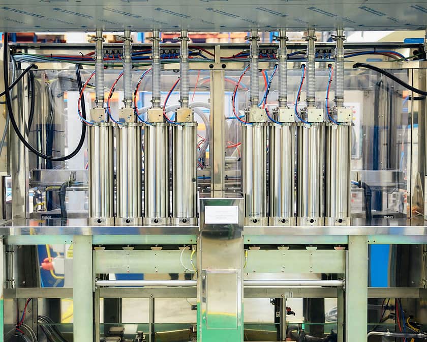 A view from the back of an Adelphi Masterfil Volumetric Fille, there are 8 volumetric canisters showing out the back of the machine.