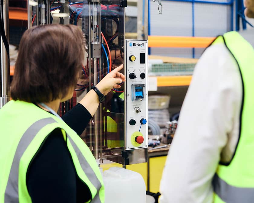 Adelphi 0607 Two people in hi vis discussing machines
