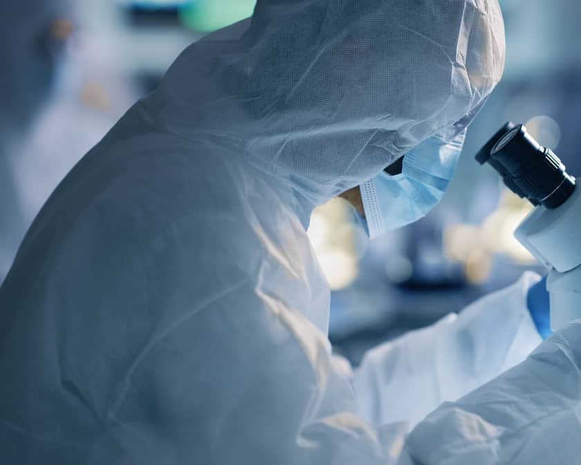 Suited Lab Staring into microscope