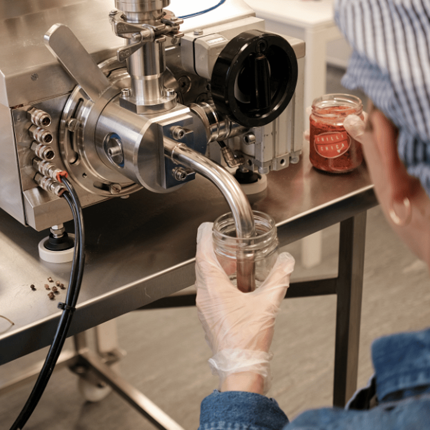 Person Filling Chilli Jam Birdseye View 600x600