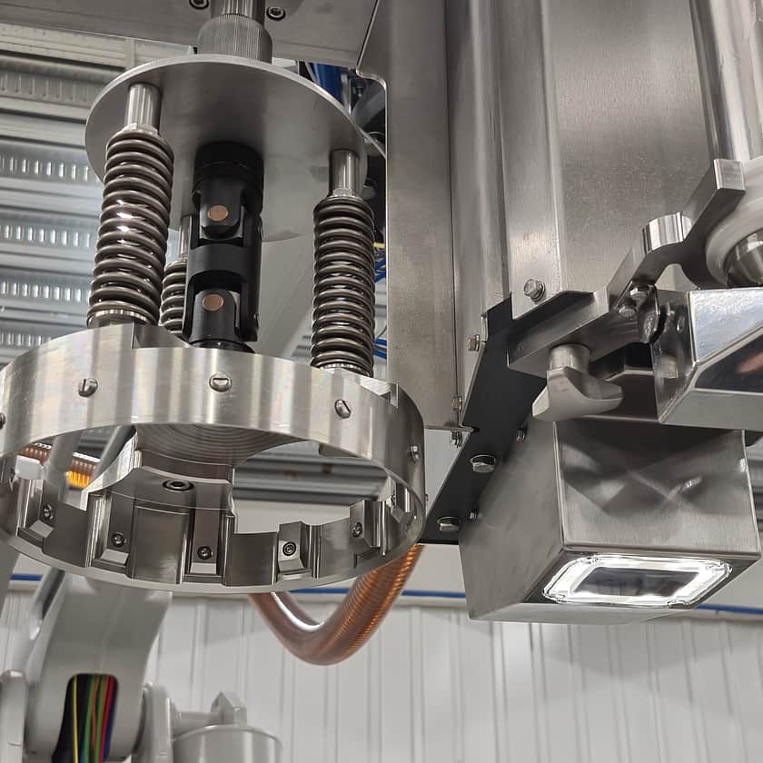Close-up of a robotic IBC filling head with automated gripper and precision filling nozzle, designed for accurate bulk liquid filling in industrial manufacturing environments.