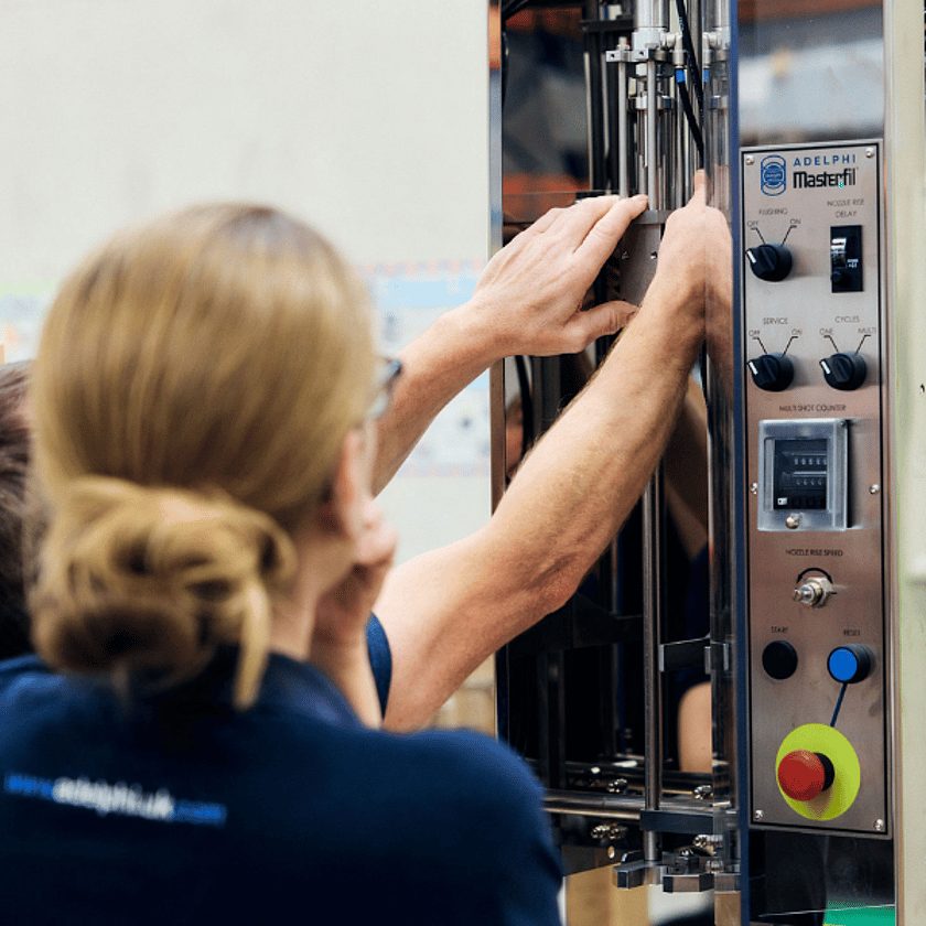 Two People Working On Semi Automatic Volumetric Filling Machine 600 x 600