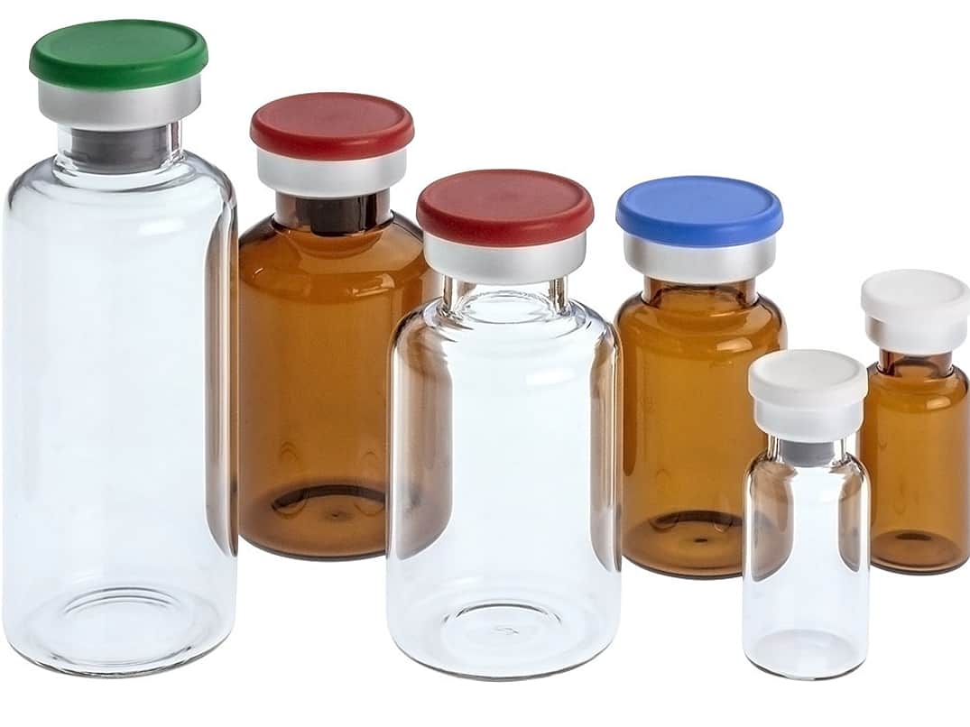 A selection of clear and brown glass bottles with coloured tops.
