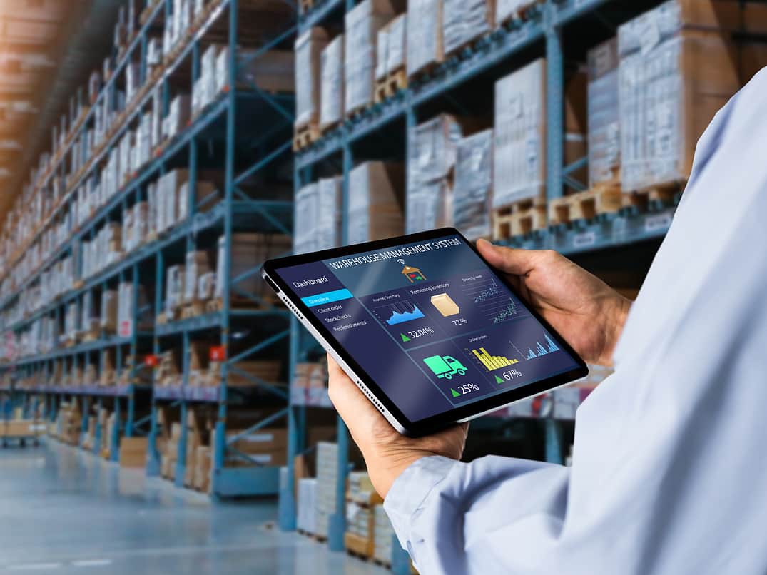 An image of someone holding an iPad in a warehouse.