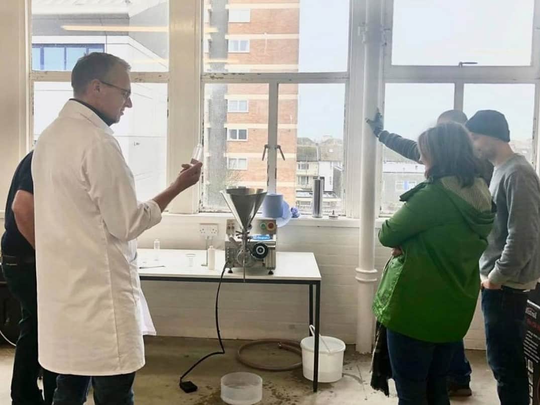 a group of five people gathered around a Reponse Benchtop Filler