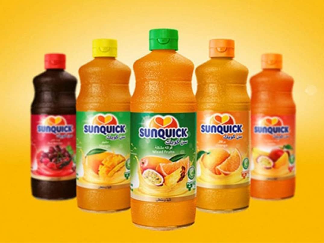 a selection of BIDCORO juice drink bottles on a bright orange background