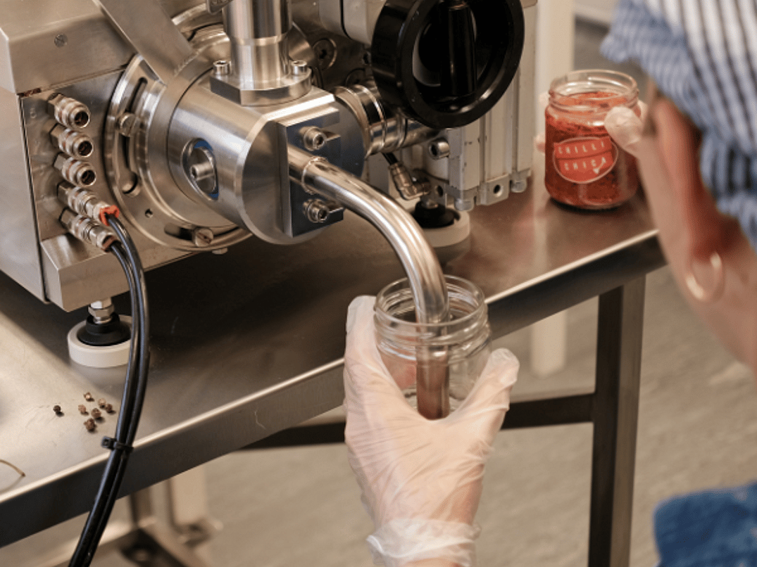 Person Filling Chilli Jam Birdseye View 600 x 600