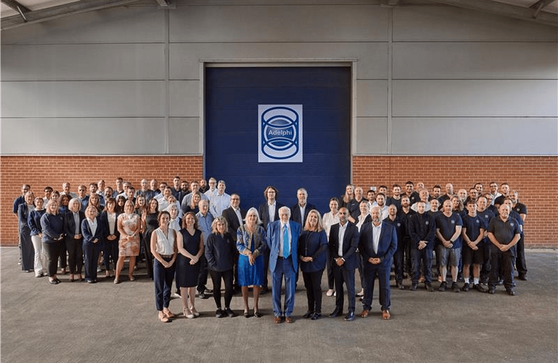Group image of Adelphi staff members standing outside an Adelphi warehouse
