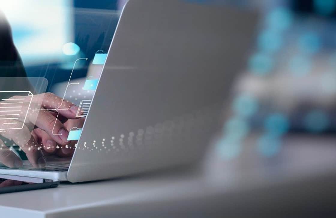 Hands hovering over a laptop keyboard