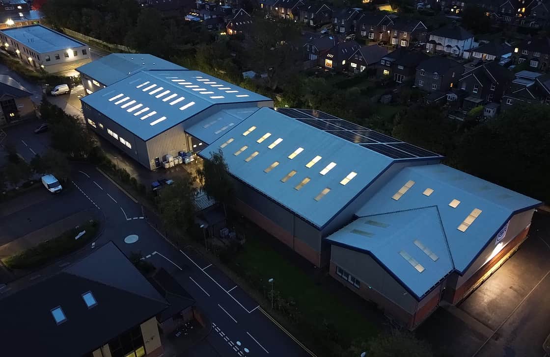 Eine Luftaufnahme des Adelphi-Geländes bei Nacht, mit beleuchteten Fenstern und sichtbaren Solarpaneelen.