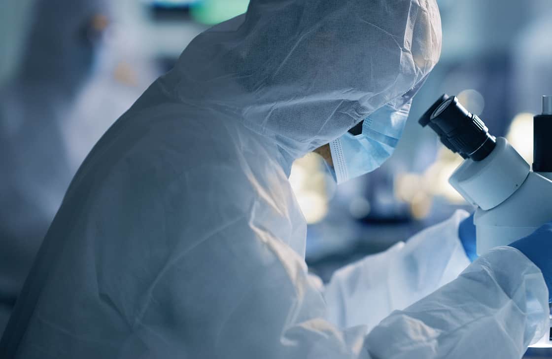 Suited Lab Staring into microscope